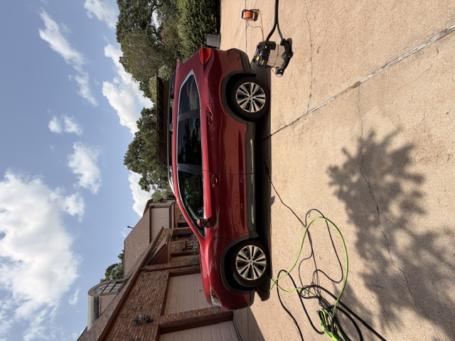 Red SUV cleaned inside and out in a residential driveway