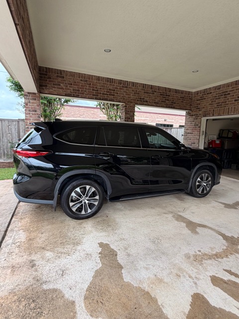 Black SUV with a mirror shine parked under a covered driveway
