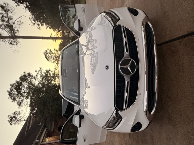 White Mercedes SUV gleaming in a driveway after a hand wash